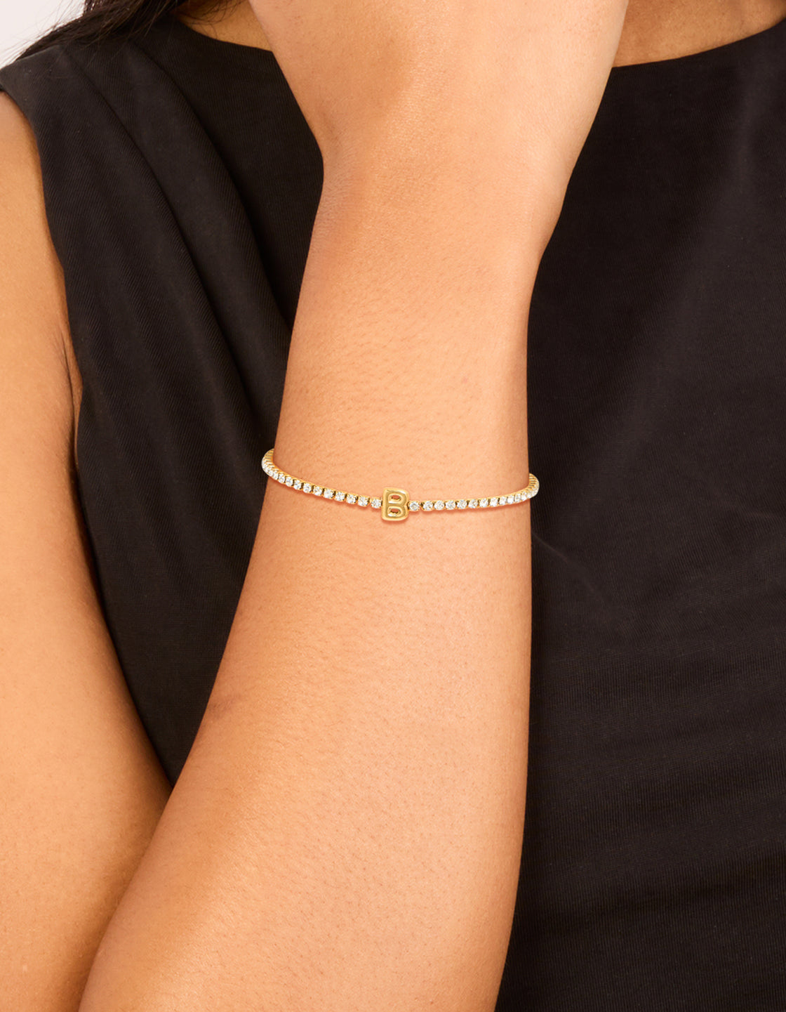 Showcasing a waterproof gold plated stainless steel cubic zirconia tennis and letter B initial bracelet on wrist view