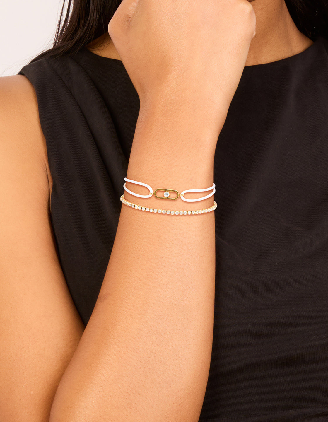 Stunning waterproof stainless steel bracelet set featuring gold plated tennis design with cubic zirconia and white cord on model view