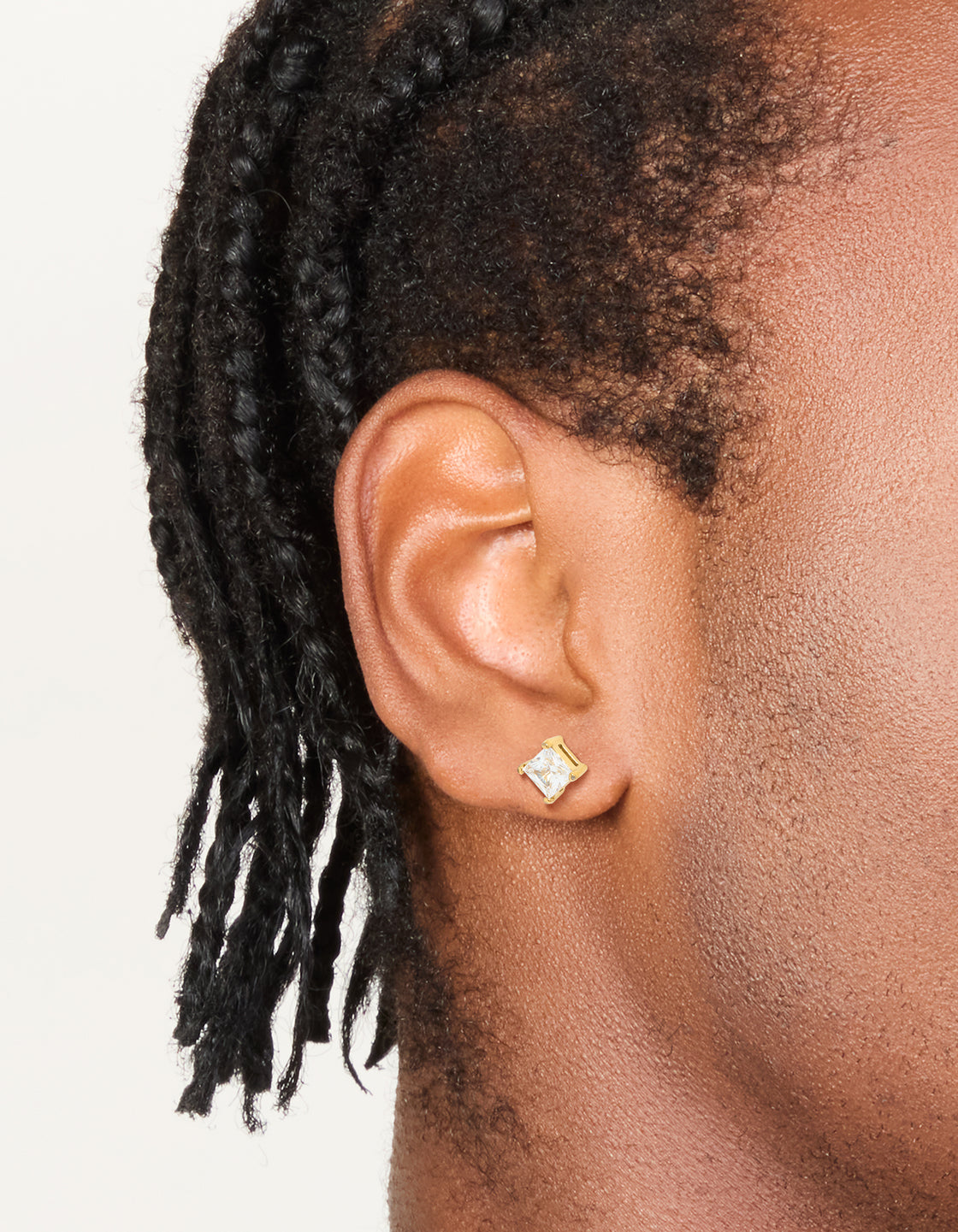 Showcasing mens waterproof small square cubic zirconia stud earrings crafted from gold plated stainless steel on ear view