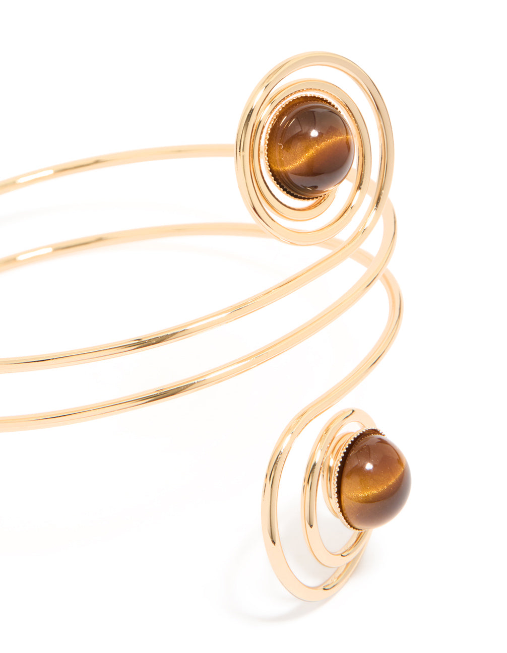 Featuring a gold swirl and brown stones arm cuff with statement design close up view