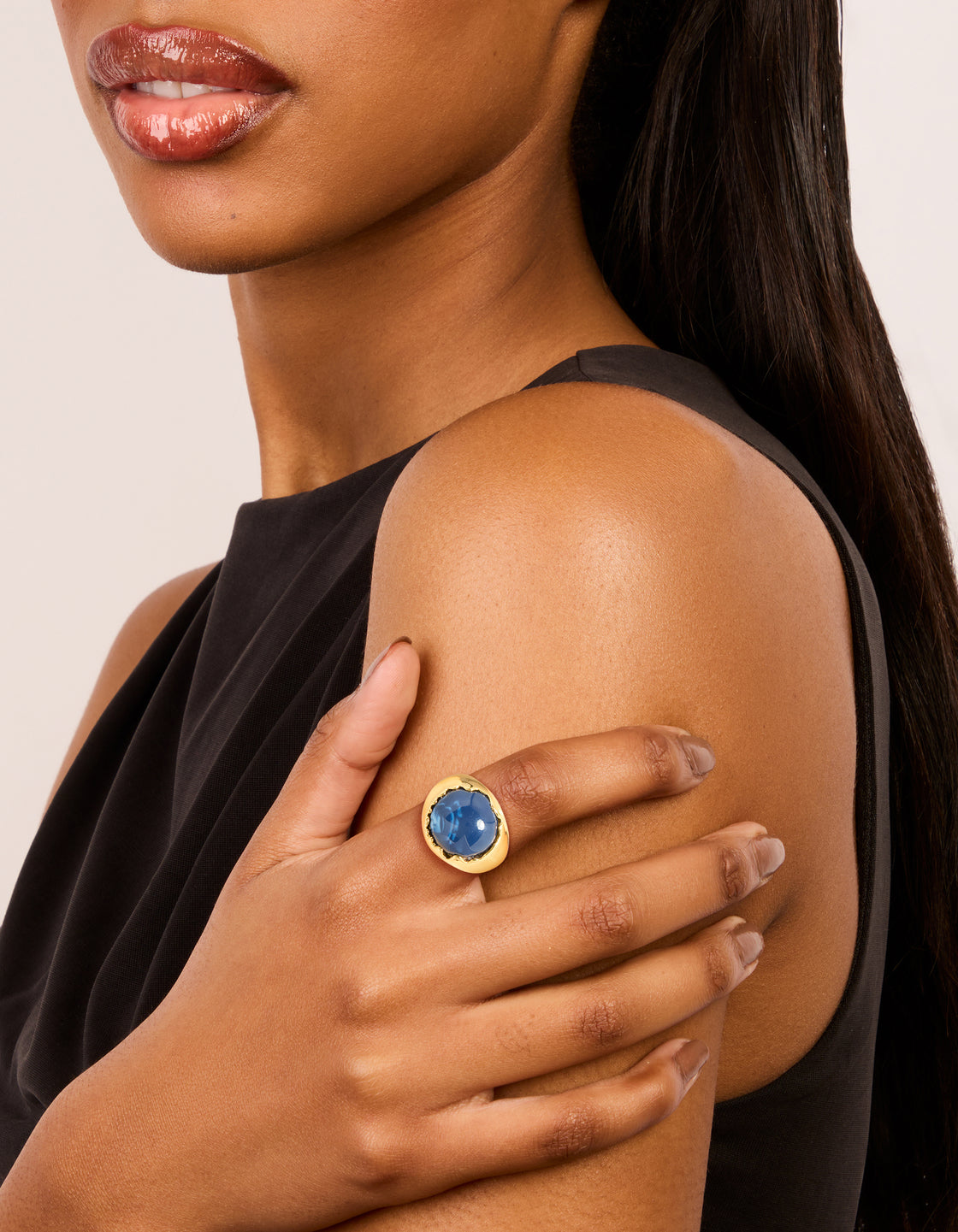 Showcasing a gold plated oversized blue jewel ring with navy stone on finger view