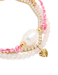 Featuring waterproof stainless steel tennis bracelet with heart, beads, cubic zirconia, cord, and freshwater pearl accents in pink, white, and gold plated finish close up view - link has visual effect only