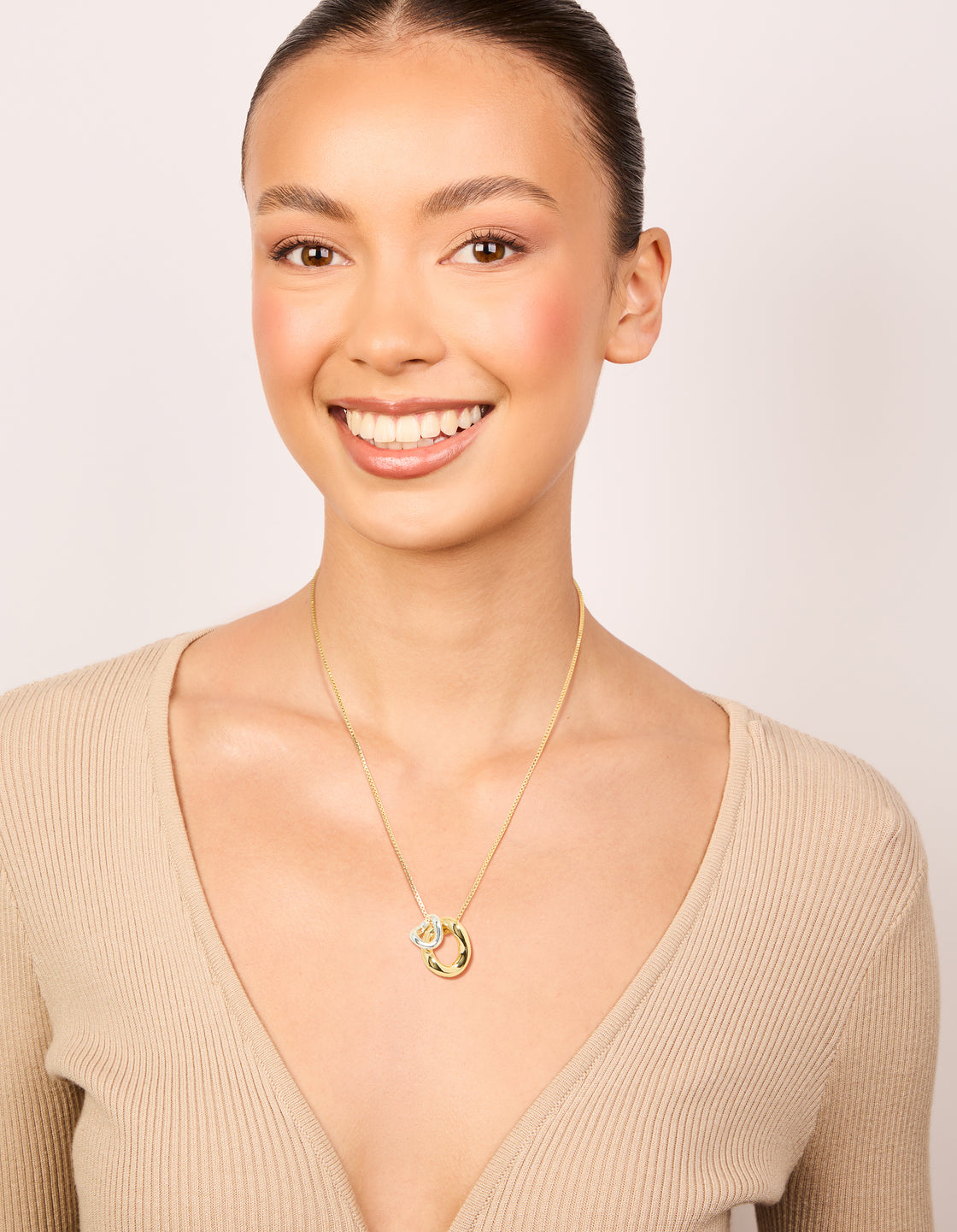 Elegantly styled mixed metal small swirl pendant necklace featuring in gold and silver plated finishes on model view