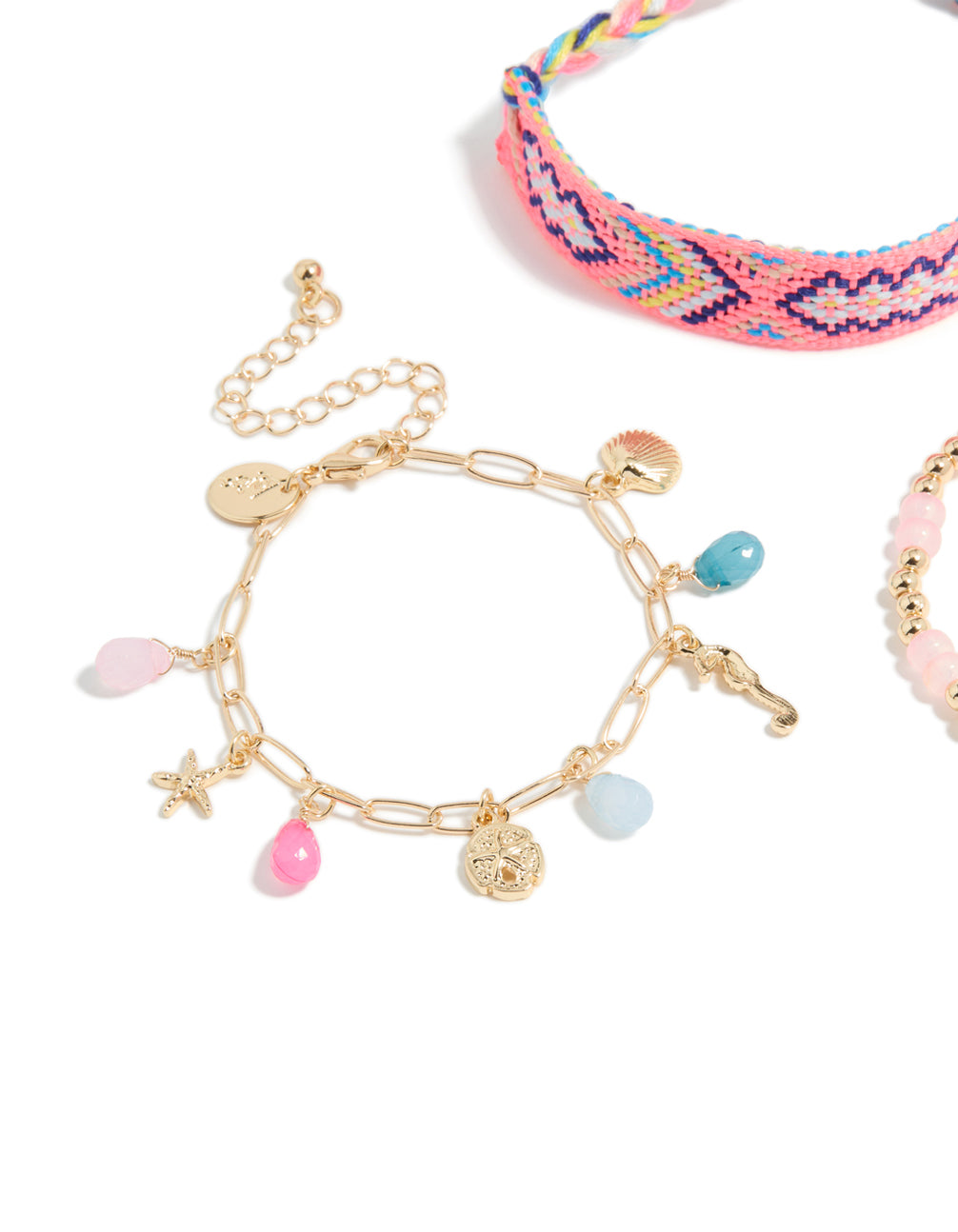 Showcasing gold pink beaded and sea charm bracelets in a 3-pack with ocean and tassel details crafted from cord close up view