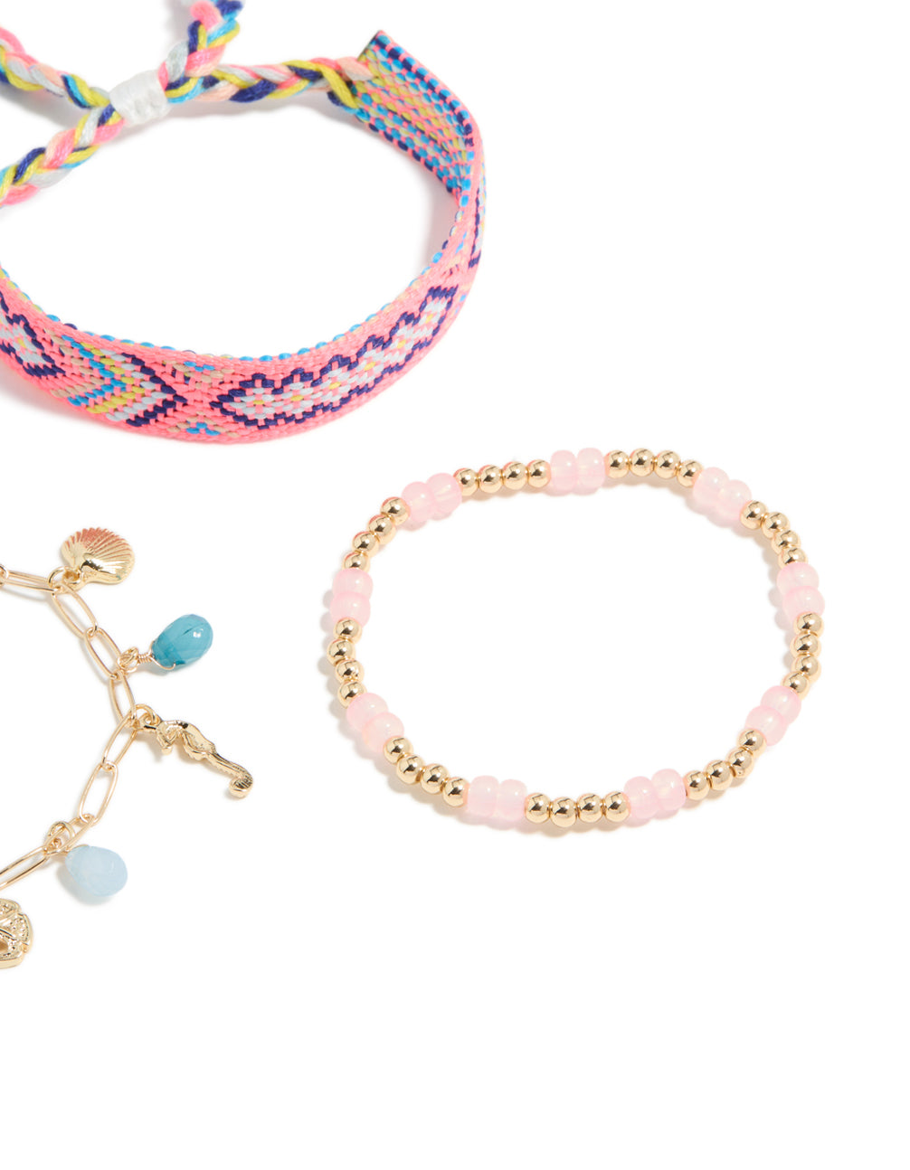 Displaying gold pink beaded and sea charm bracelets in a 3-pack with ocean and tassel details crafted from cord closure detail view