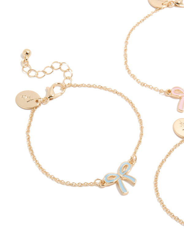 Crafted from enamel, kids bow bracelets in gold with pink and light blue accents, 3-pack close up view