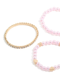 Showcasing kids beaded pearl and heart stretch bracelets in a 5-pack featuring tassel details in gold, light pink, ivory, and salmon hues close up view - link has visual effect only
