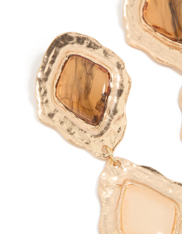 Showcasing textured metalwork, these gold molten Aztec drop earrings reveal statement styling in close up view