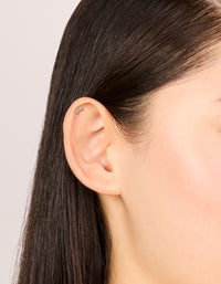 Showcasing gold plated titanium earrings with baguette cut cubic zirconia stones in a 3-pack and flat back closure on ear view - link has visual effect only
