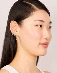 Crafted with mixed metal plated cubic zirconia bezel stud and huggie earrings in a 3-pack, gold, silver, and clear tones on model view - link has visual effect only