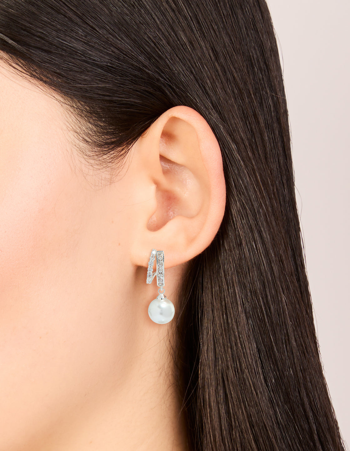Elegant silver plated cubic zirconia illusion pearl drop earrings with hoop closure on ear view