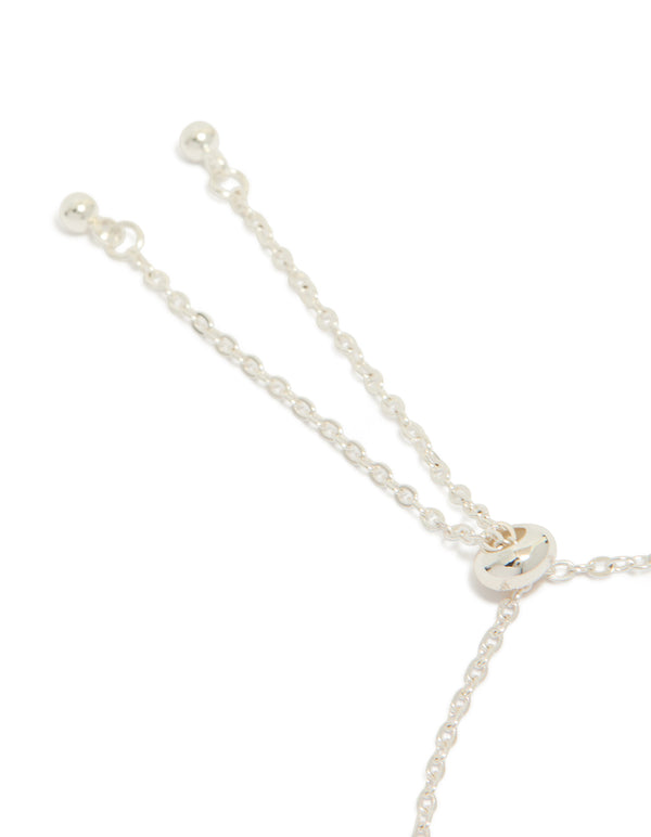 This silver plated oval toggle bracelet with floral and charms features cubic zirconia in pink and clear stone closure detail view