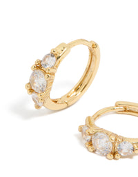 Shop gold plated mixed sized cubic zirconia mini huggie earrings with huggie closure close up view - link has visual effect only
