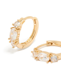 Featuring gold cubic zirconia dainty huggie earrings close up view - link has visual effect only