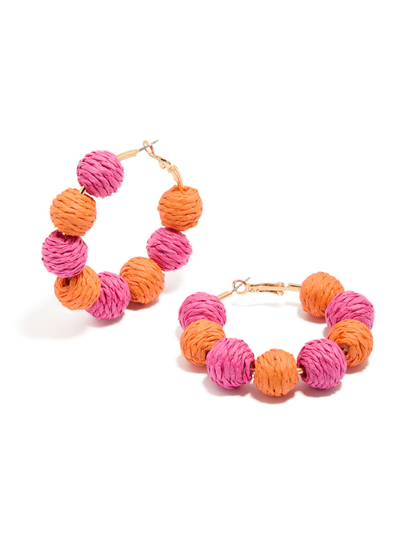 Showcasing statement hoop earrings with paper balls in hot pink, coral and gold front view