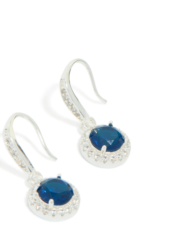 Elegant drop earrings featuring sapphire blue cubic zirconia with halo cut and plated finish close up view