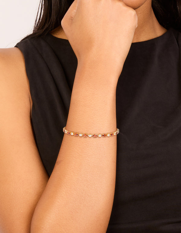 Featuring a gold plated clear and cognac cubic zirconia multi cut tennis bracelet on wrist view