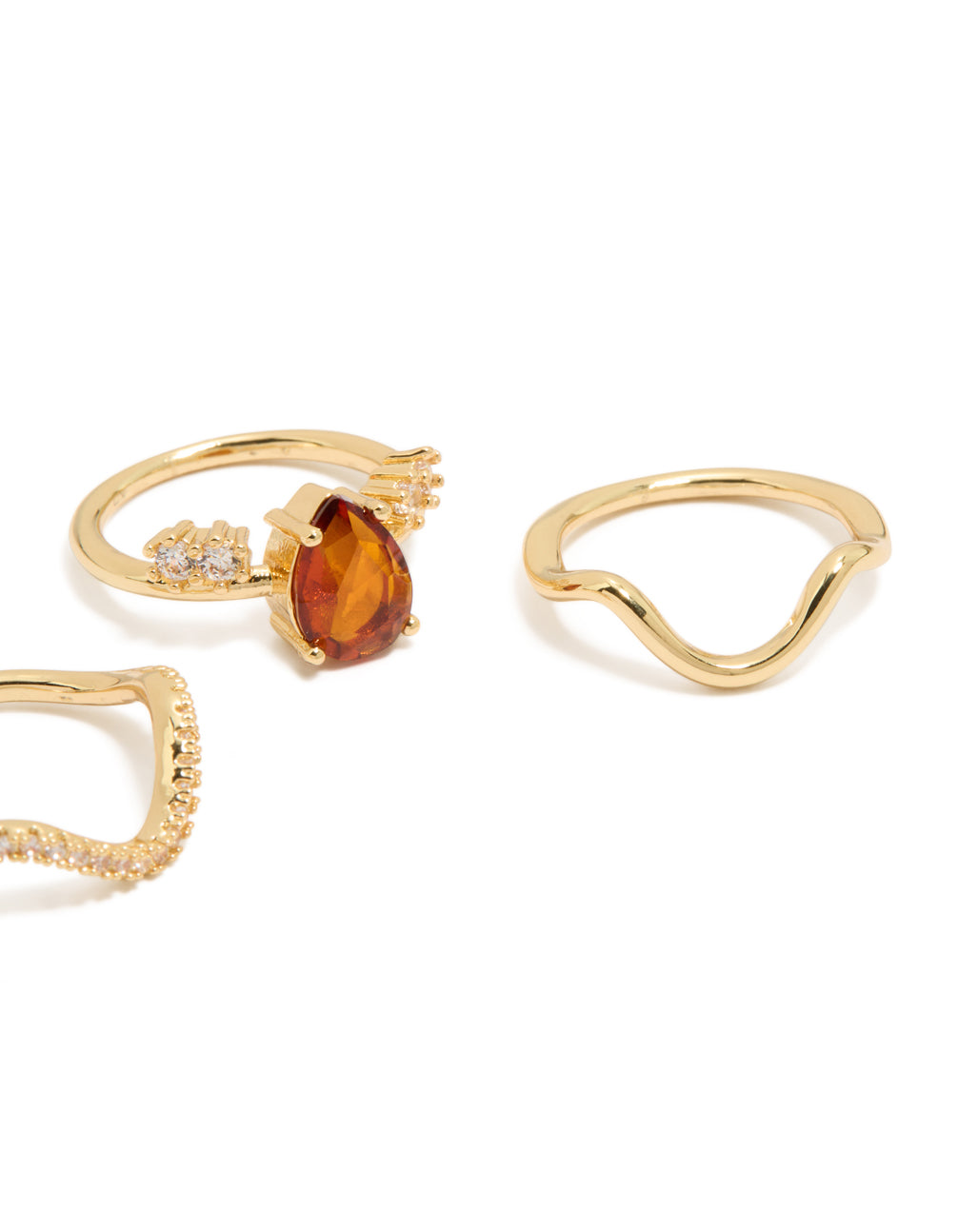 Displaying gold plated red cubic zirconia teardrop and wavy rings in a statement 3-pack with crystal accents side detail view
