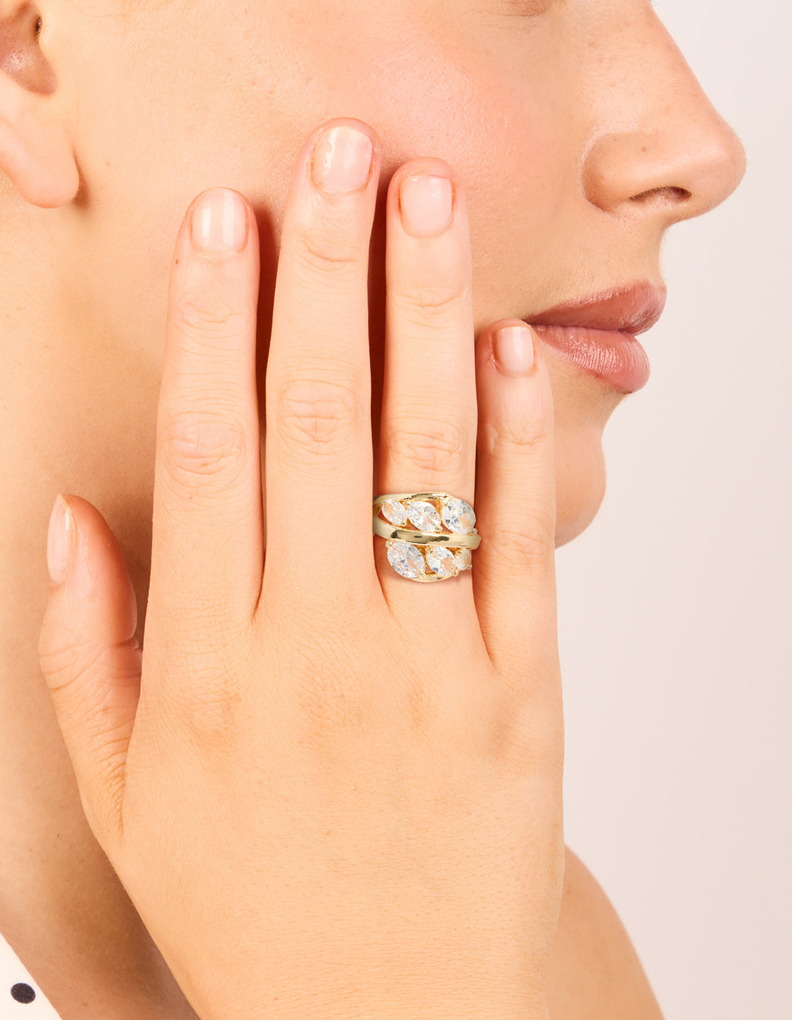 Crafted from gold plated metal featuring cubic zirconia oval clusters in a layered statement ring on finger view
