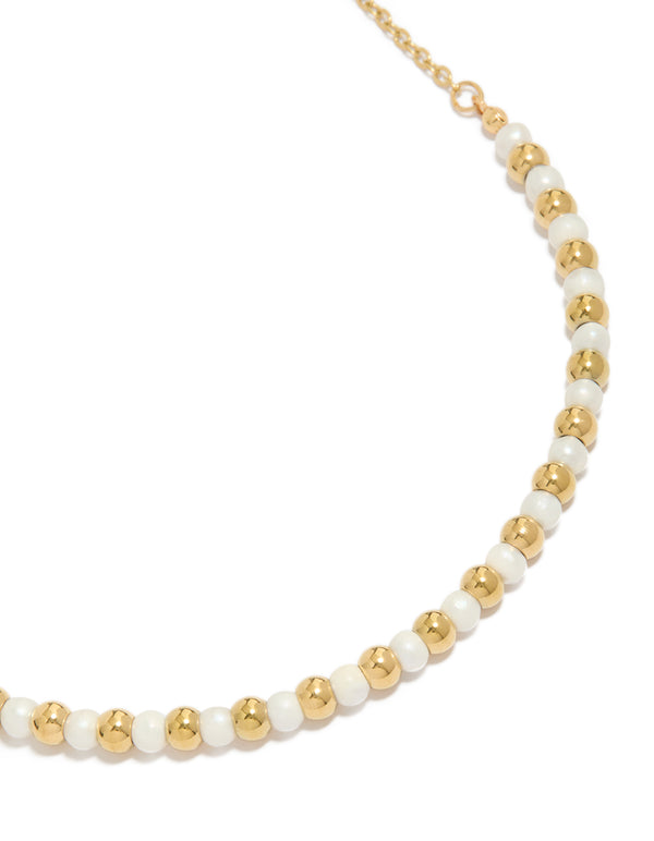 Elegant waterproof beaded necklace featuring alternating gold plated stainless steel balls and pearl close up view