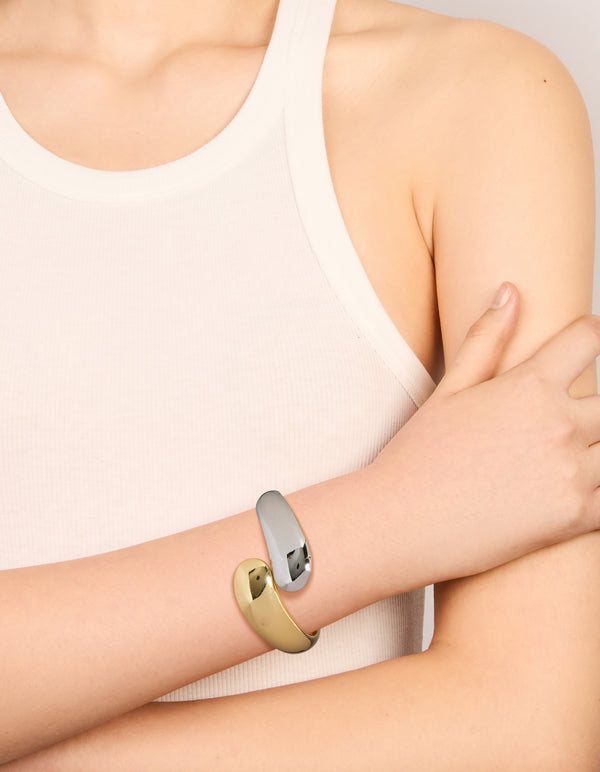 Featuring a waterproof mixed plated stainless steel round twisted cuff bangle in silver and gold with chunky styling on wrist view