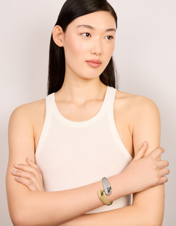 Designed with a waterproof mixed plated stainless steel round twisted cuff bangle in silver and gold with chunky styling on model view