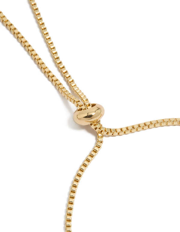 Highlighting a gold plated bracelet with cubic zirconia flower and pearl rondell charm accents in toggle design closure detail view