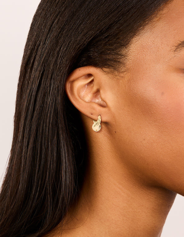Featuring gold plated wavy hoop earrings with statement style on ear view