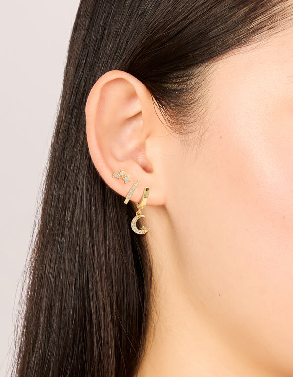 Featuring celestial charm gold plated cubic zirconia and crescent moon hoop earrings 3-pack with crystal huggie closure in clear stone on ear view