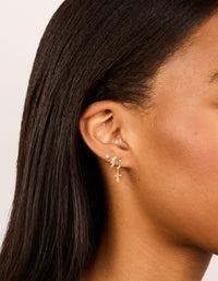 Featuring dainty charm and cross huggie with trio baguette studs crafted from gold plated cubic zirconia in a 3-pack on ear view - link has visual effect only