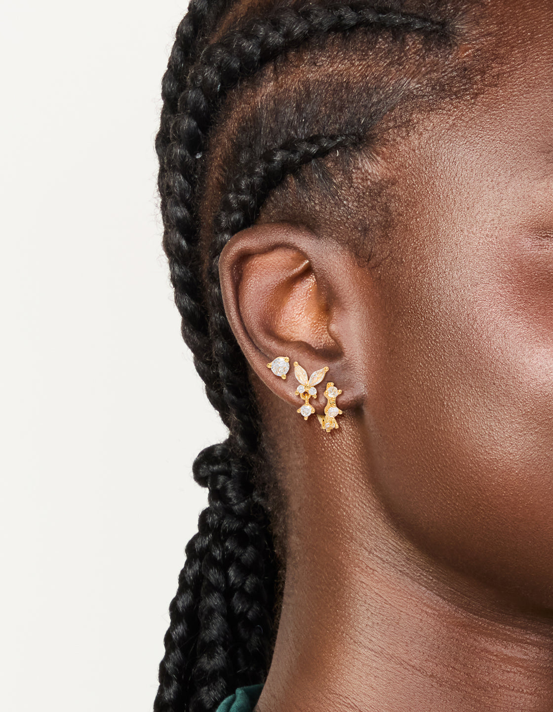 Designed with gold plated mini butterfly hoop earrings in a 3-pack with cubic zirconia crystal huggie and stud closures on ear view