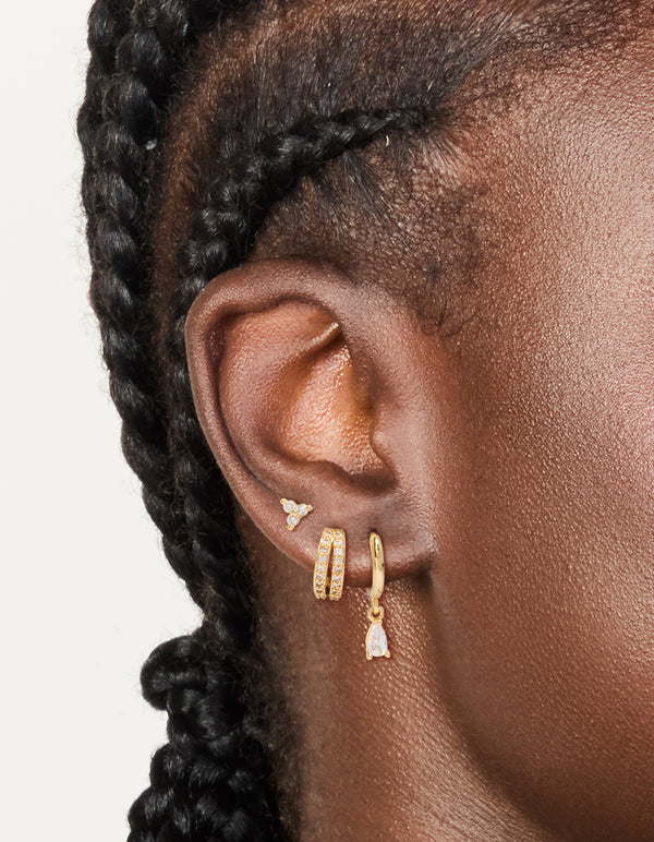 Featuring dainty gold plated cubic zirconia trio and huggie earrings 3-pack with crystal closure on ear view