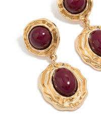 Showcasing statement gold double burgundy resin drop earrings with textured metal framing and maroon stones close up view - link has visual effect only