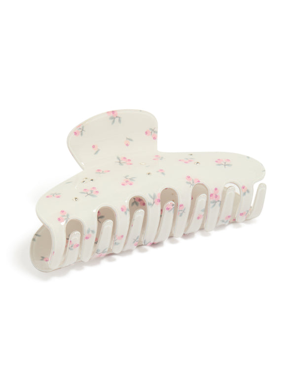 Showcasing a white acrylic claw clip with floral diamante pink flowers and light green accents side view