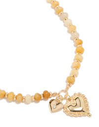 Showcasing a gold semi precious stone beaded duo heart necklace with charm feature close up view - link has visual effect only