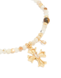 Designed with a gold plated beaded bracelet featuring cross charm and cubic zirconia crystal details close up view - link has visual effect only