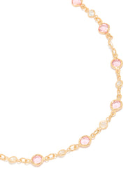 Showcasing a gold pink and clear cubic zirconias round station necklace close up view - link has visual effect only
