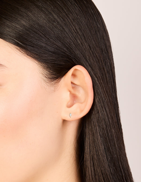 These gold plated surgical steel stud earrings with marquise cut cubic zirconia and flat back closure on ear view
