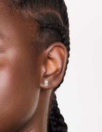Featuring oval cut cubic zirconia studs in gold plated surgical steel with flat back closure on ear view - link has visual effect only