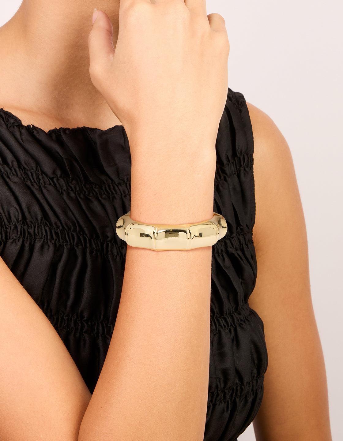 Featuring a gold plated bamboo statement bangle on wrist view