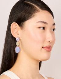 Crafted with statement drop earrings featuring oval cut stones in purple and orange hues set in gold on model view - link has visual effect only