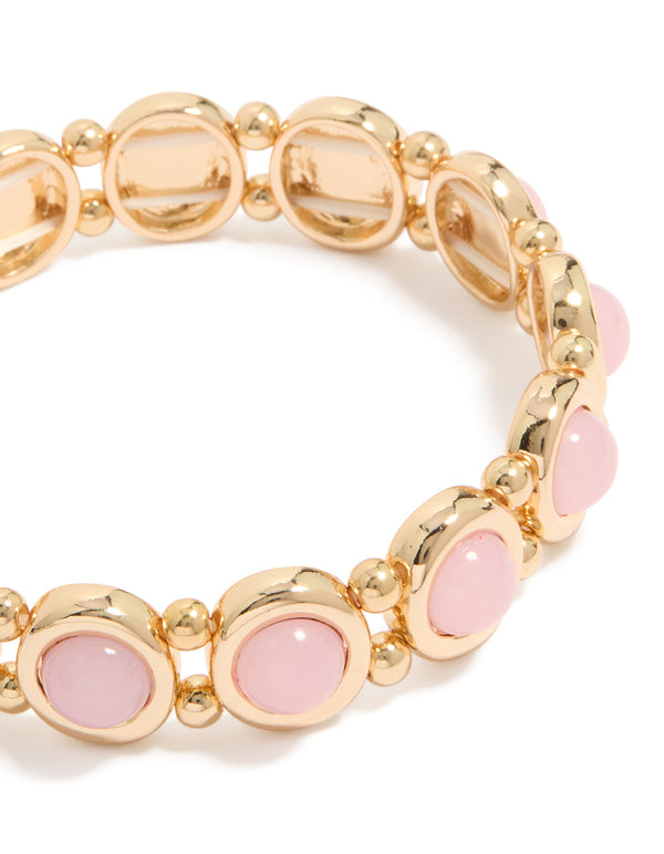 Featuring a beaded organic shaped stretch bracelet in gold and pink close up view