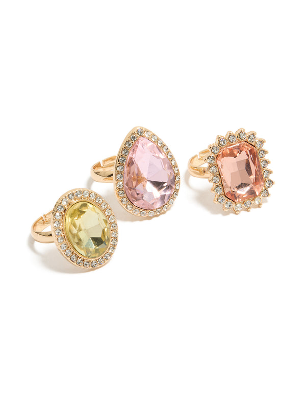 Showcasing a statement halo and oval stone cut diamante ring 3-pack in pink and purple pastel tones front view