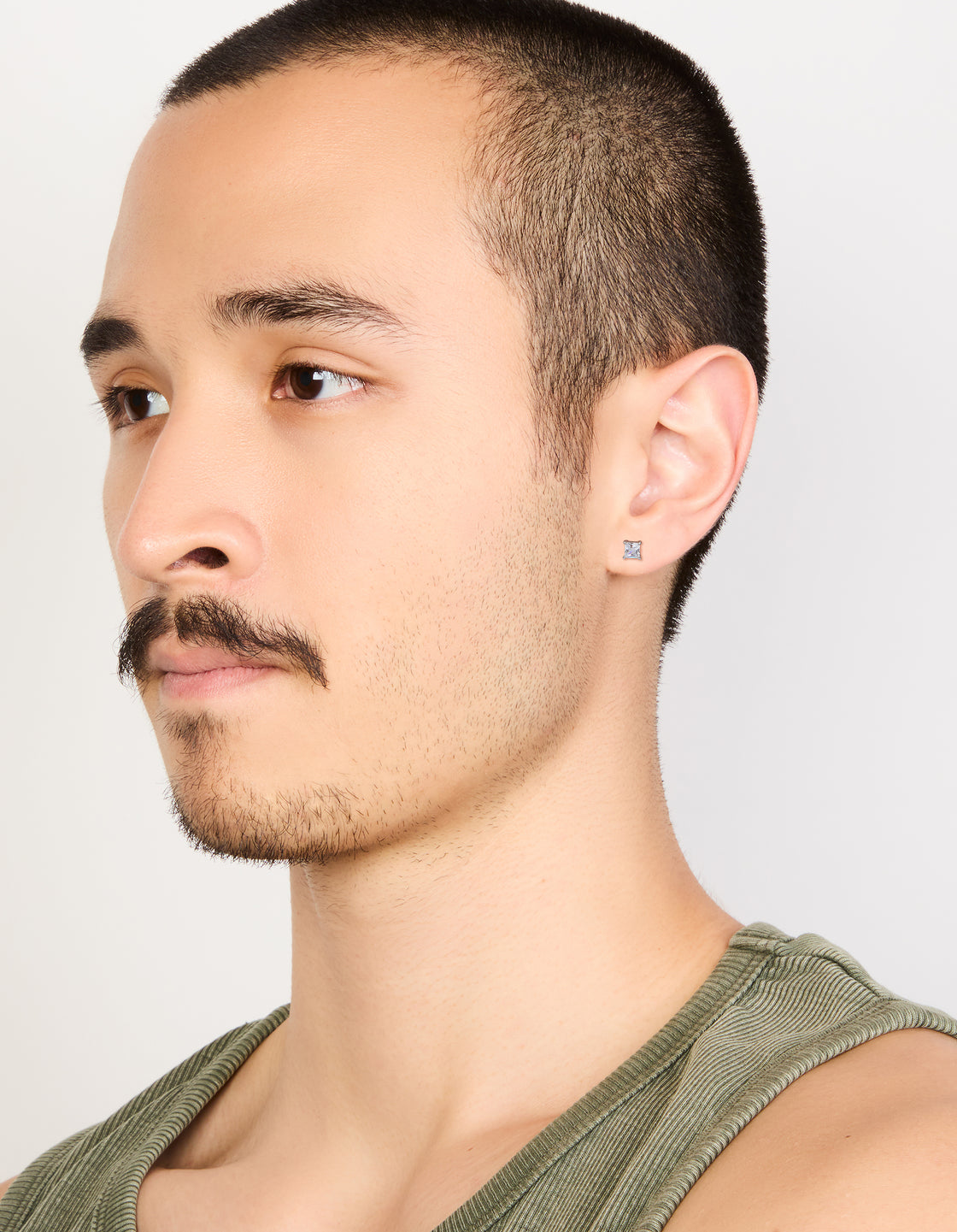 Featuring mens waterproof mini square clear cubic zirconia stud earrings crafted from stainless steel in silver on model view