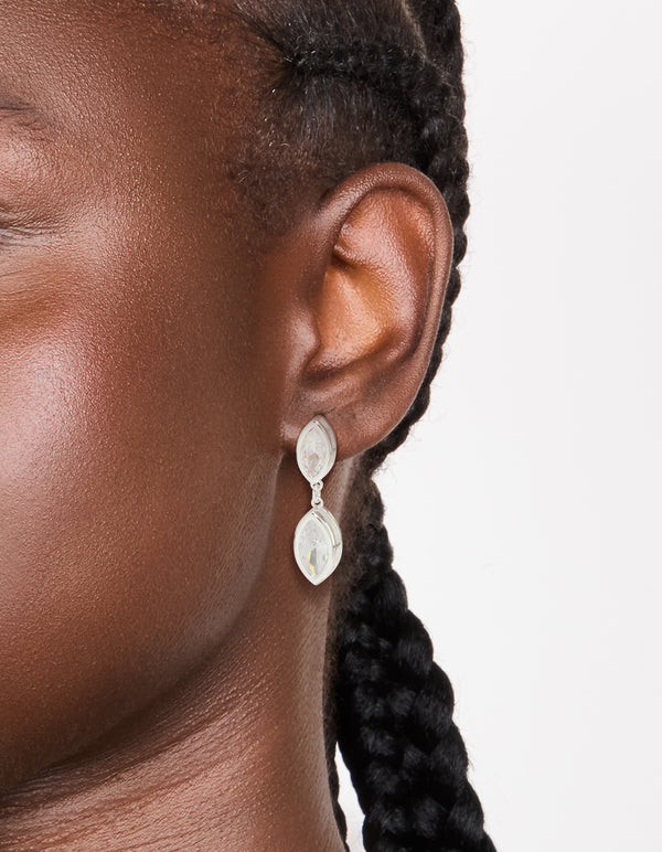 Featuring silver plated cubic zirconia double oval bezel drop earrings with clear stones in on ear view