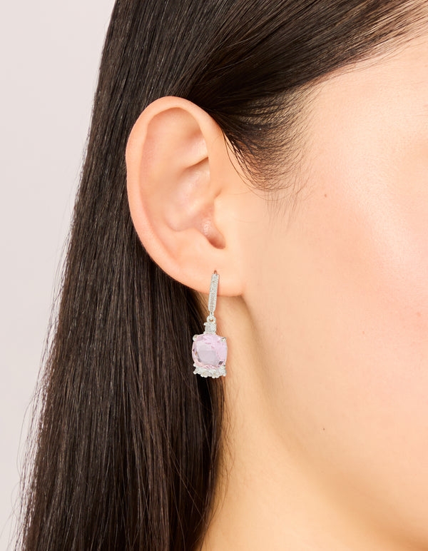 Showcasing silver plated cubic zirconia pink square drop huggie earrings with crystal detailing on ear view