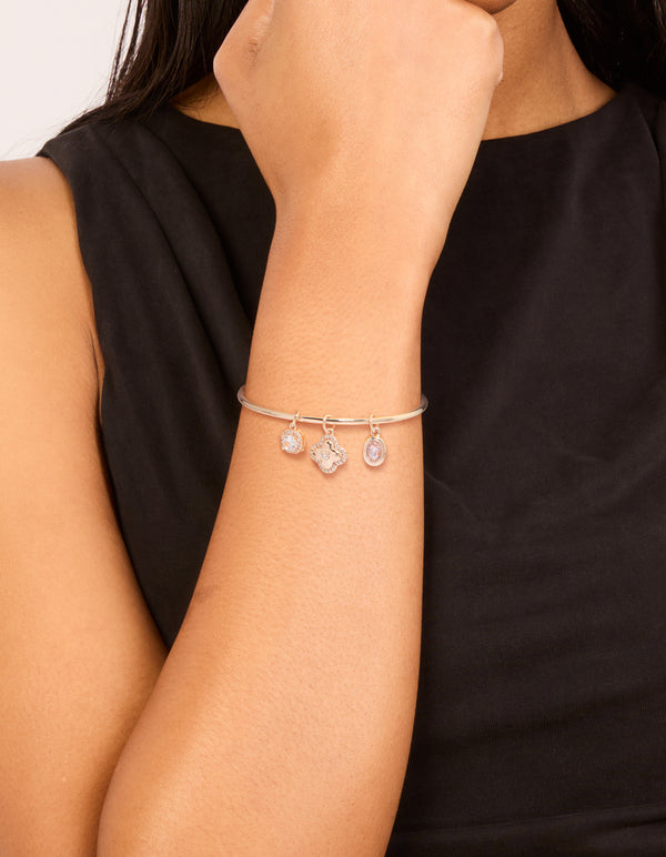 Featuring floral charm toggle bangle in rose gold plated material with cubic zirconia, pink and rose gold tones on wrist view