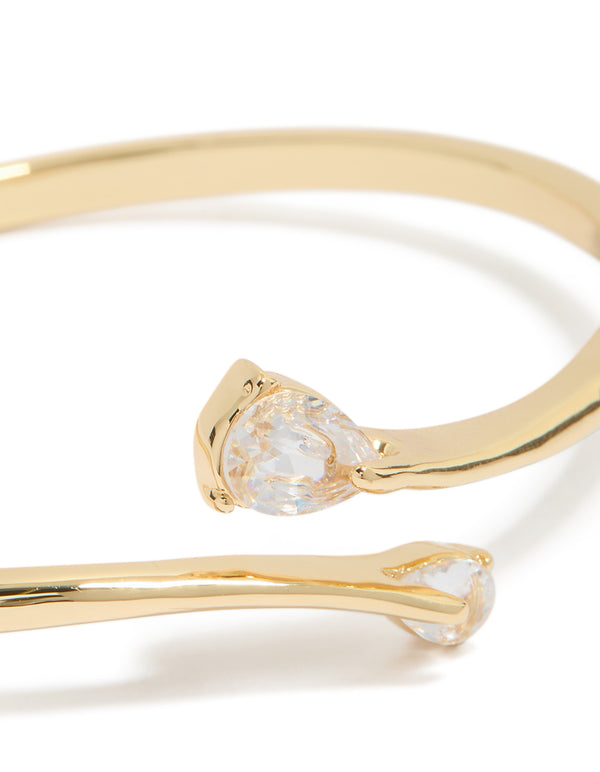 Showcasing gold plated cubic zirconia flat teardrop open front bangle with statement design close up view