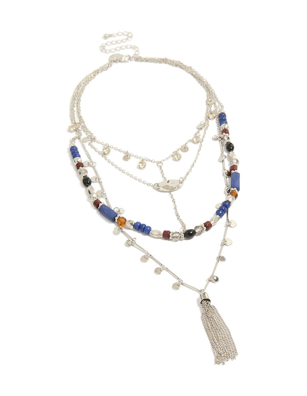 Crafted with cubic zirconia and crystal, this blue and brown beaded layered necklace features a coin and tassel charm disc, finished in silver and shown in a front view