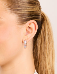 Showcasing chunky floral enamel huggie earrings in lavender and light pink with gold accents on ear view - link has visual effect only